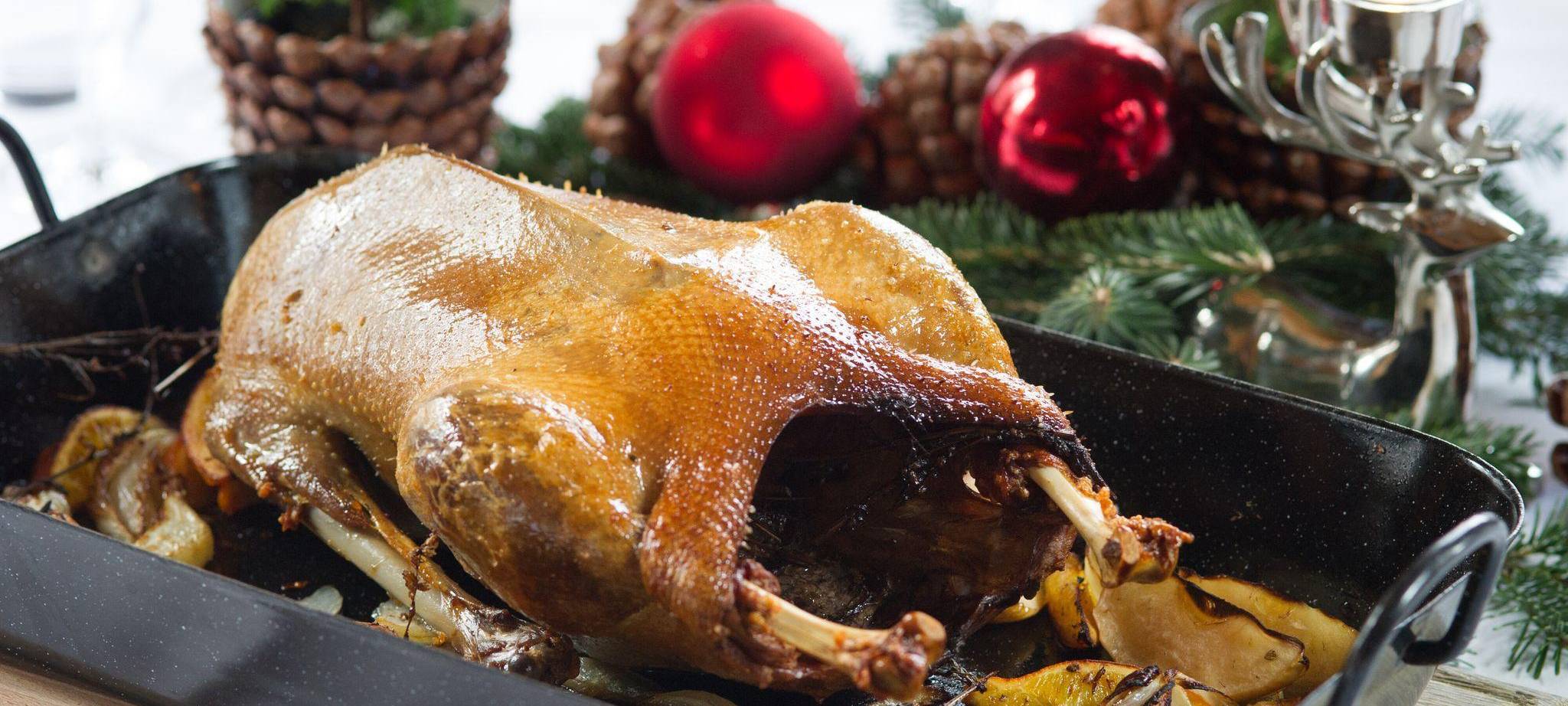 Eine Gänsebraten steht auf einem festlich gedeckten Tisch