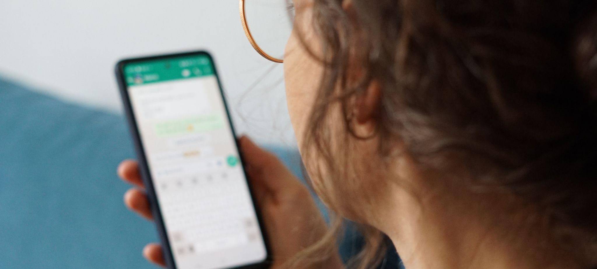 Eine junge Frau liest eine Nachricht auf einem Smartphone